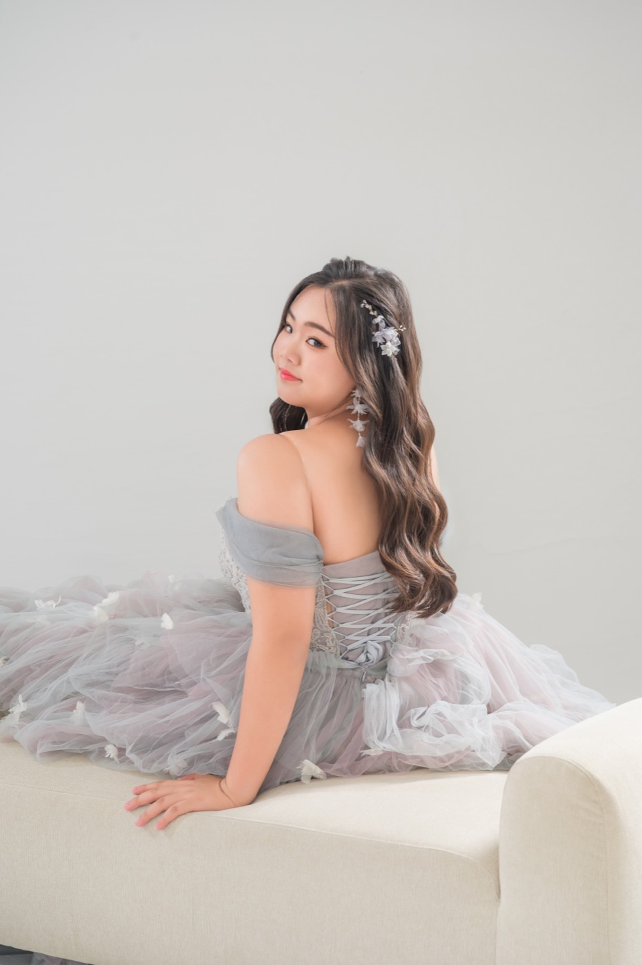 Melody looking back over her shoulder in a grey tulle gown